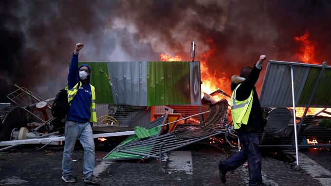 Protesters wearing yellow vests, a symbol of a French drivers' protest against higher fuel prices, shout out slogans during riots on the Champs-Elysees in Paris